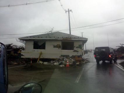 倒壊し、道をふさぐ民家の写真